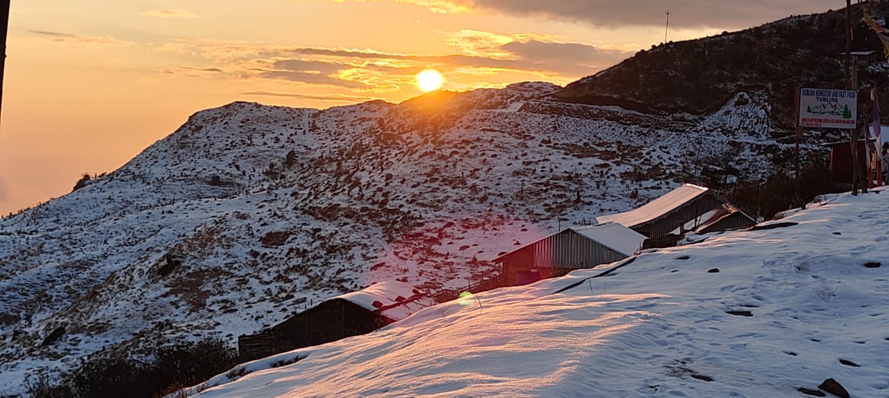 Deep red and orange sunrise above silhouetted Himalayan skyline